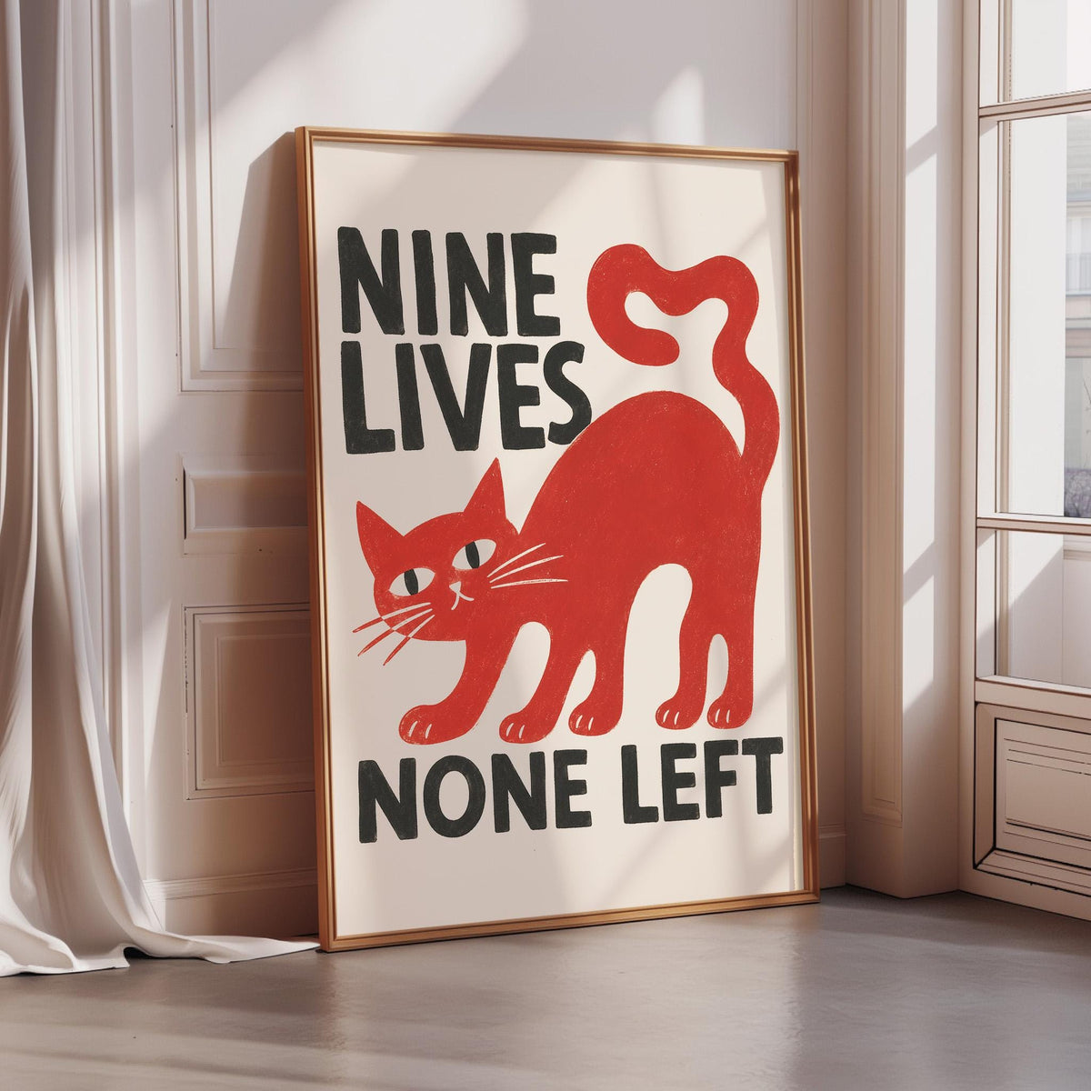 A framed poster with a red cat and the text "NINE LIVES NONE LEFT" is displayed on a wall.