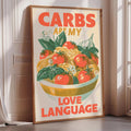 A framed poster with the text "CARBS ARE MY LOVE LANGUAGE" and an illustration of a bowl of food with tomatoes and other vegetables.
