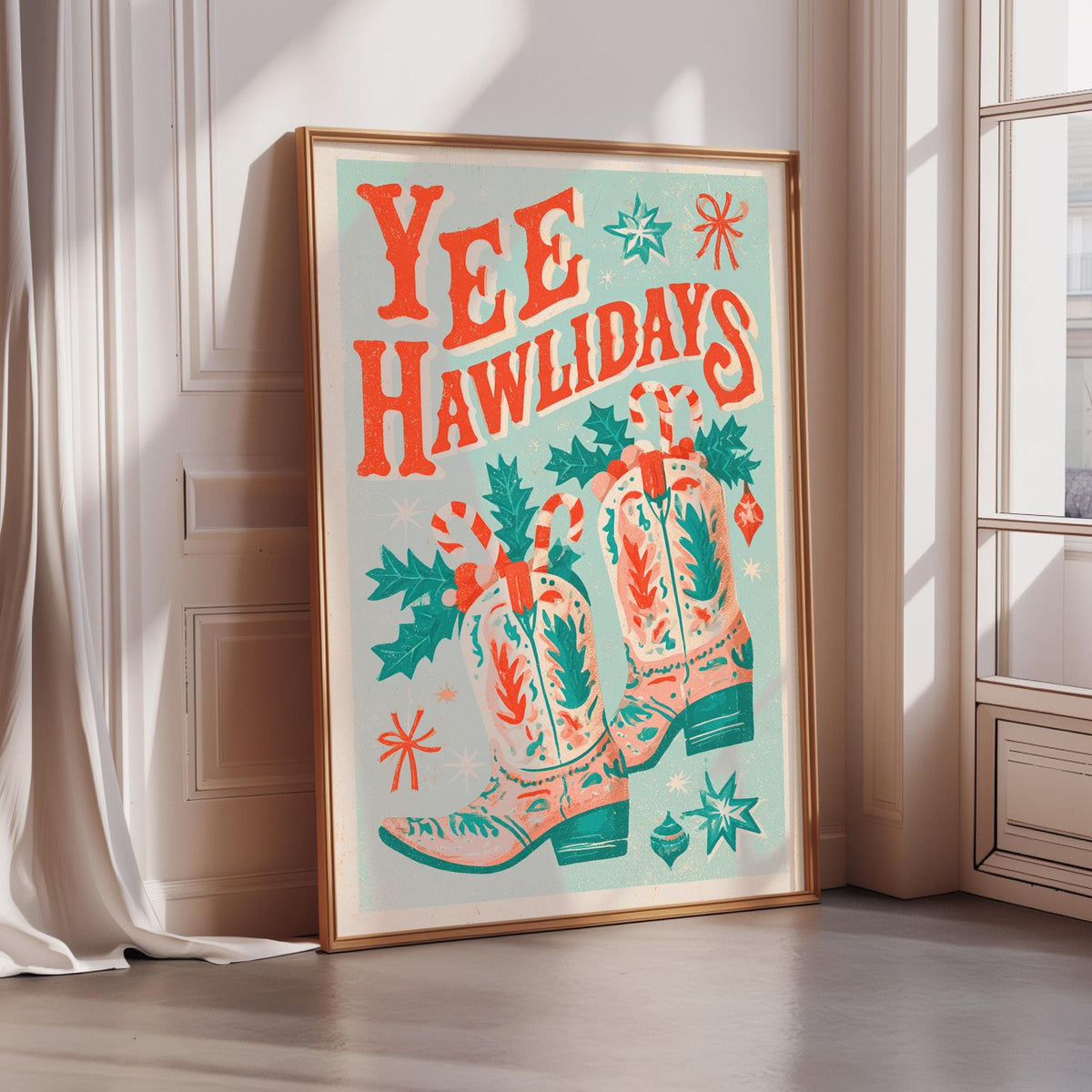 A framed poster with a festive design featuring a pair of colorful cowboy boots, Christmas decorations, and the text "YEE HAWLIDAYS"