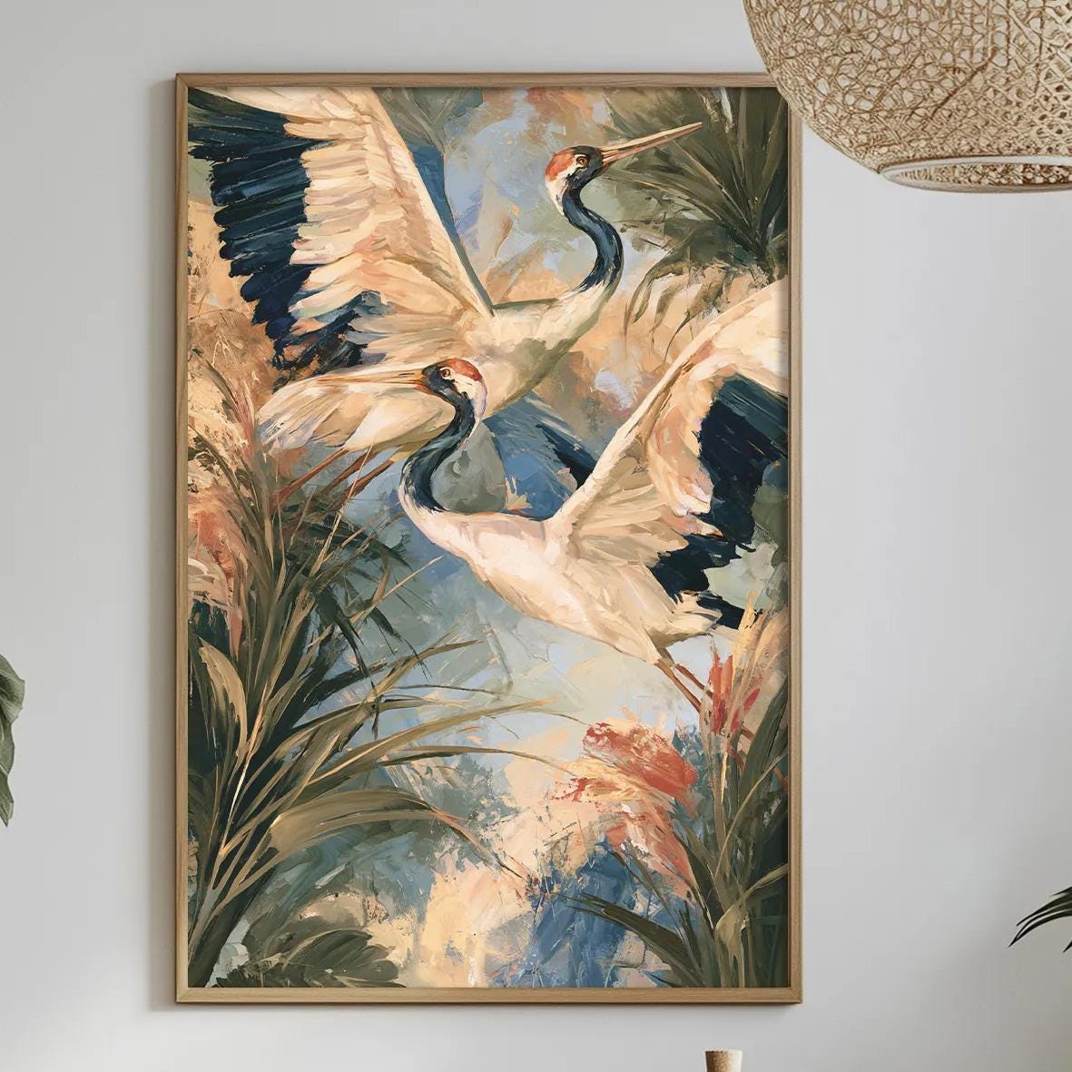 a dining table with a white tablecloth, a bowl of fruit, a bottle, and a vase with flowers. Above the table, there is a framed painting of a bird in flight, and a hanging light fixture.