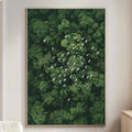 a large framed picture of a lush green forest with a flock of white birds flying over it, hanging on a wall in a living room setting.