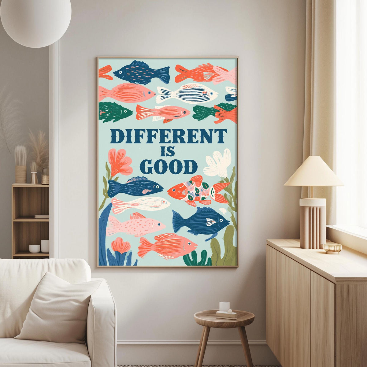 a poster with a colorful illustration of fish and the text "DIFFERENT IS GOOD" displayed on a wall in a living room setting.
