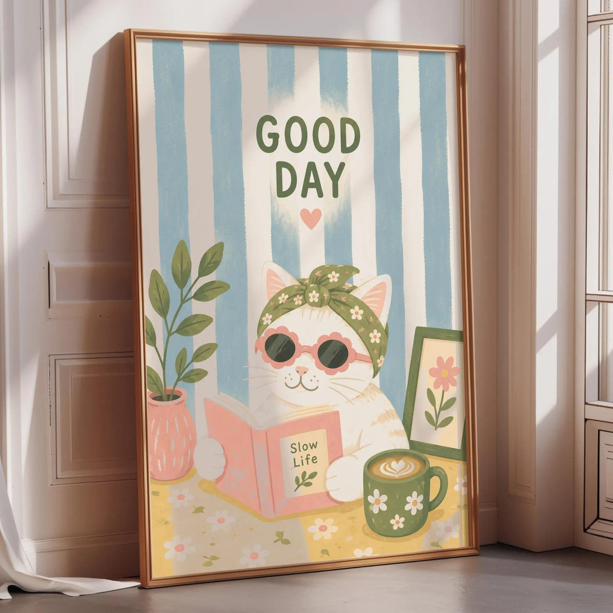 A framed poster with a cat wearing sunglasses and a flower crown, holding a book and surrounded by flowers and plants, with the text "GOOD DAY" displayed prominently.