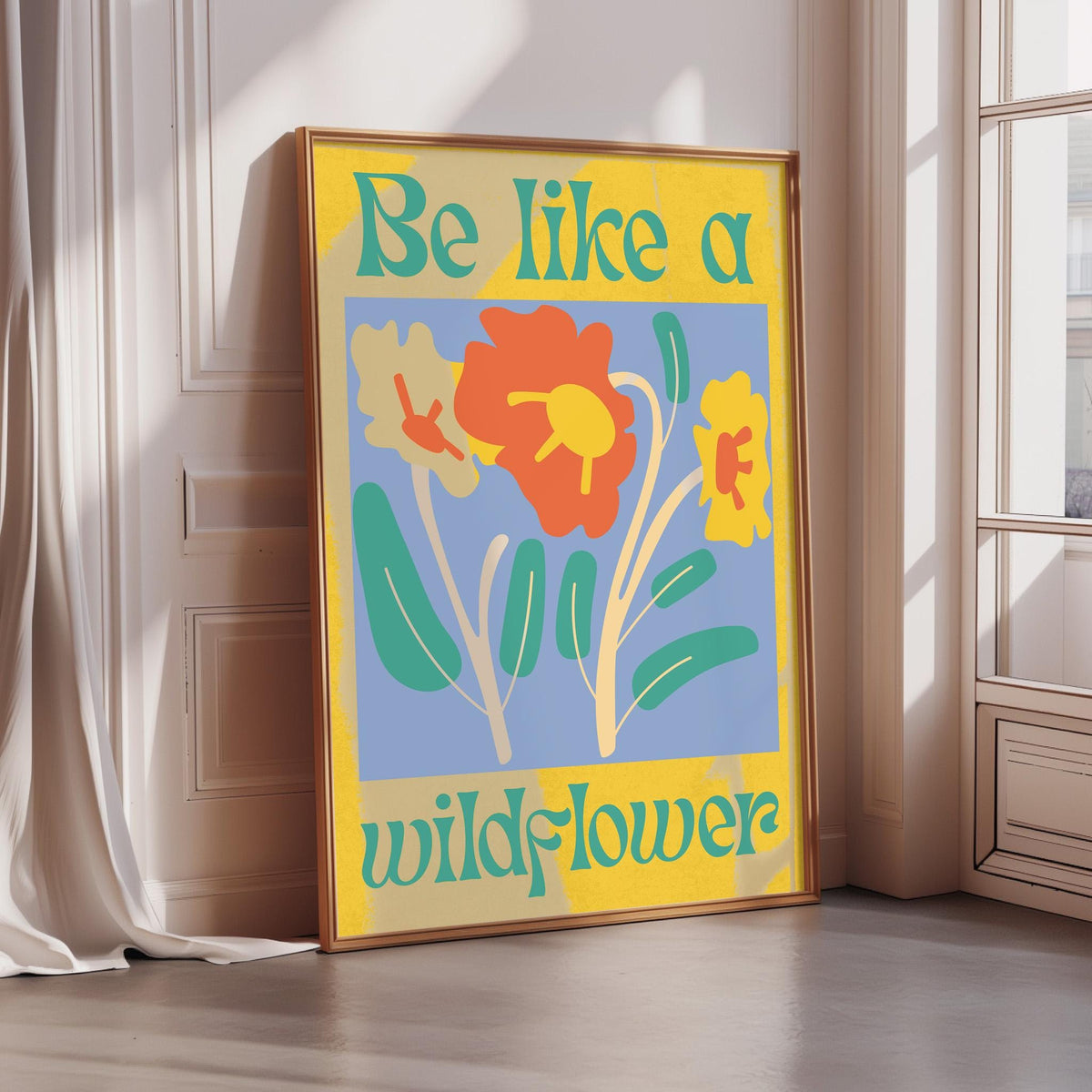 A framed poster with a colorful floral design and the text "Be Like a Wildflower" is displayed on a wall.