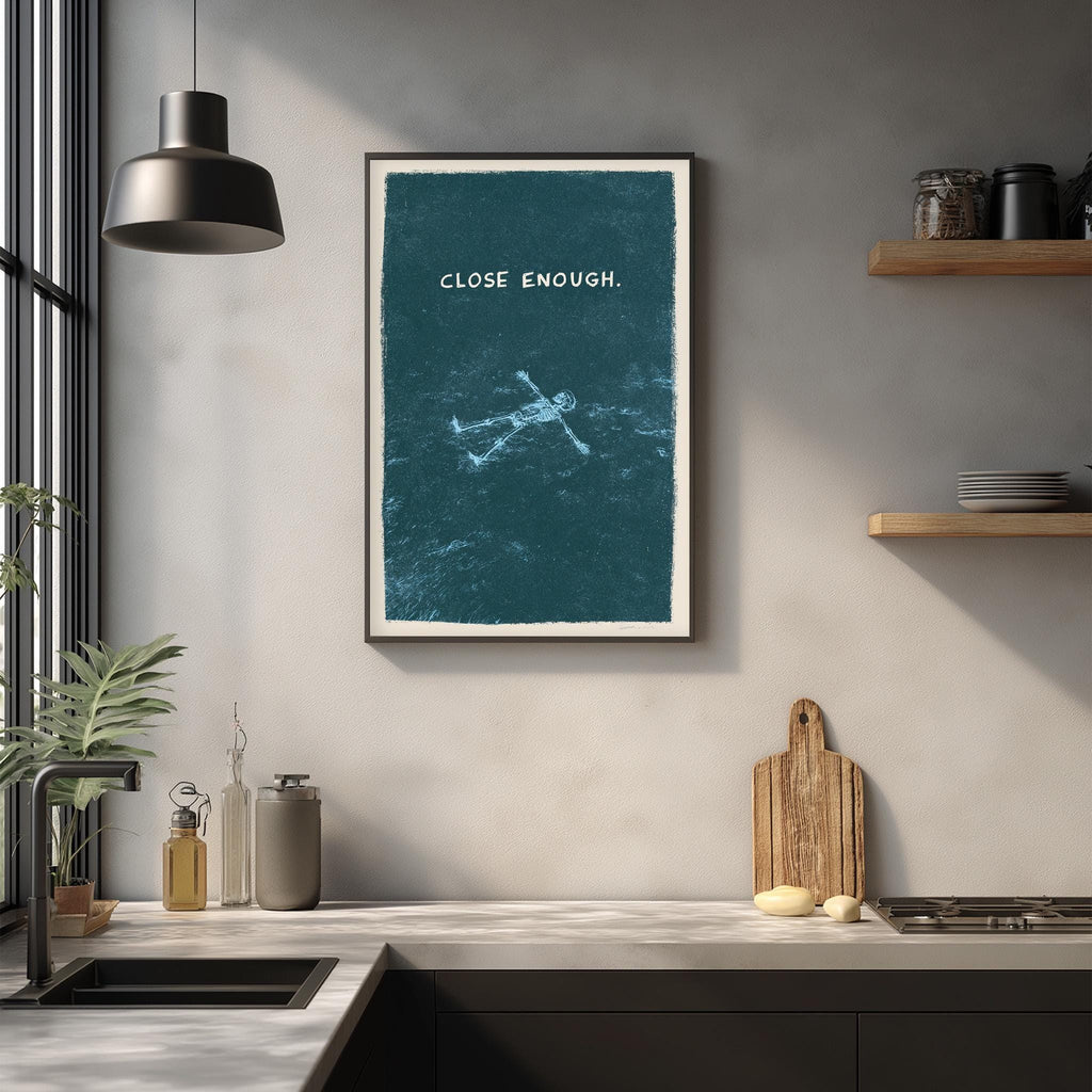 a kitchen counter with a framed poster of a person floating in water, a wooden cutting board, and various kitchen items such as a bottle, a vase, and a bowl.