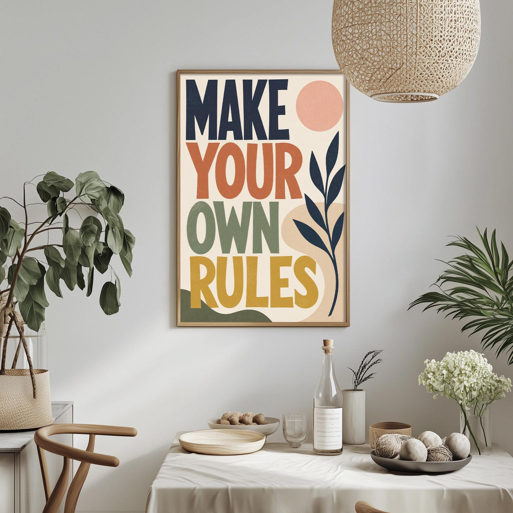 a framed poster with the text "MAKE YOUR OWN RULES" hanging on a wall above a dining table with various decorative items and plants.