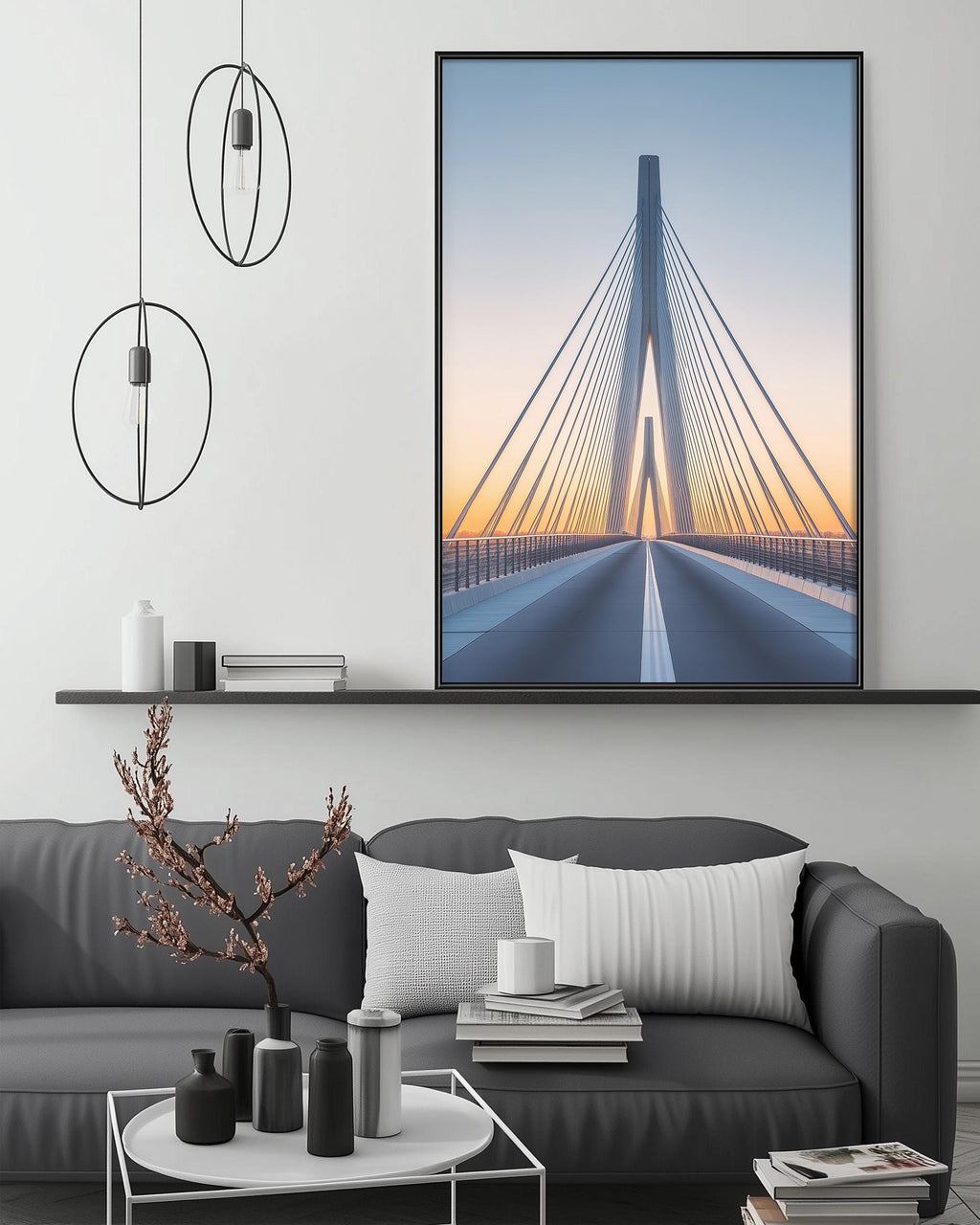 a modern living room with a gray sofa, a coffee table, and a large framed picture of a bridge with a sunset in the background.