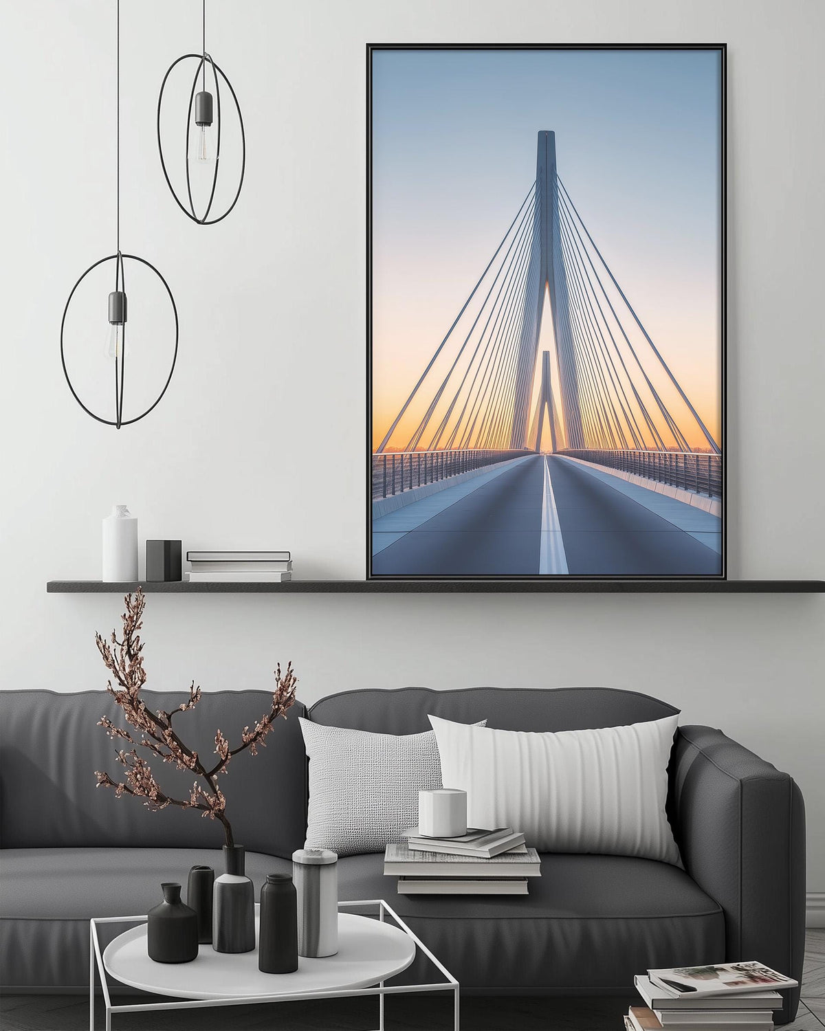 a modern living room with a gray sofa, a coffee table, and a large framed picture of a bridge with a sunset in the background.
