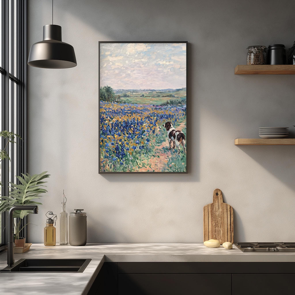 a framed painting of a field of flowers hanging on a wall above a kitchen counter.