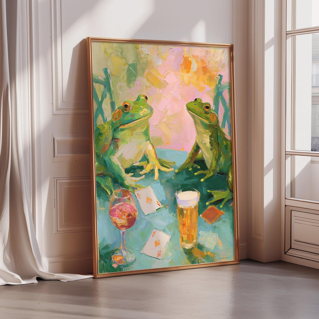 The image is a painting of two green frogs sitting at a table with a glass of wine and playing cards in front of them.