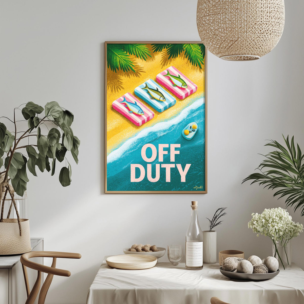 a framed poster with a beach scene, including a towel, a bottle, and a bowl, hanging on a wall above a dining table.