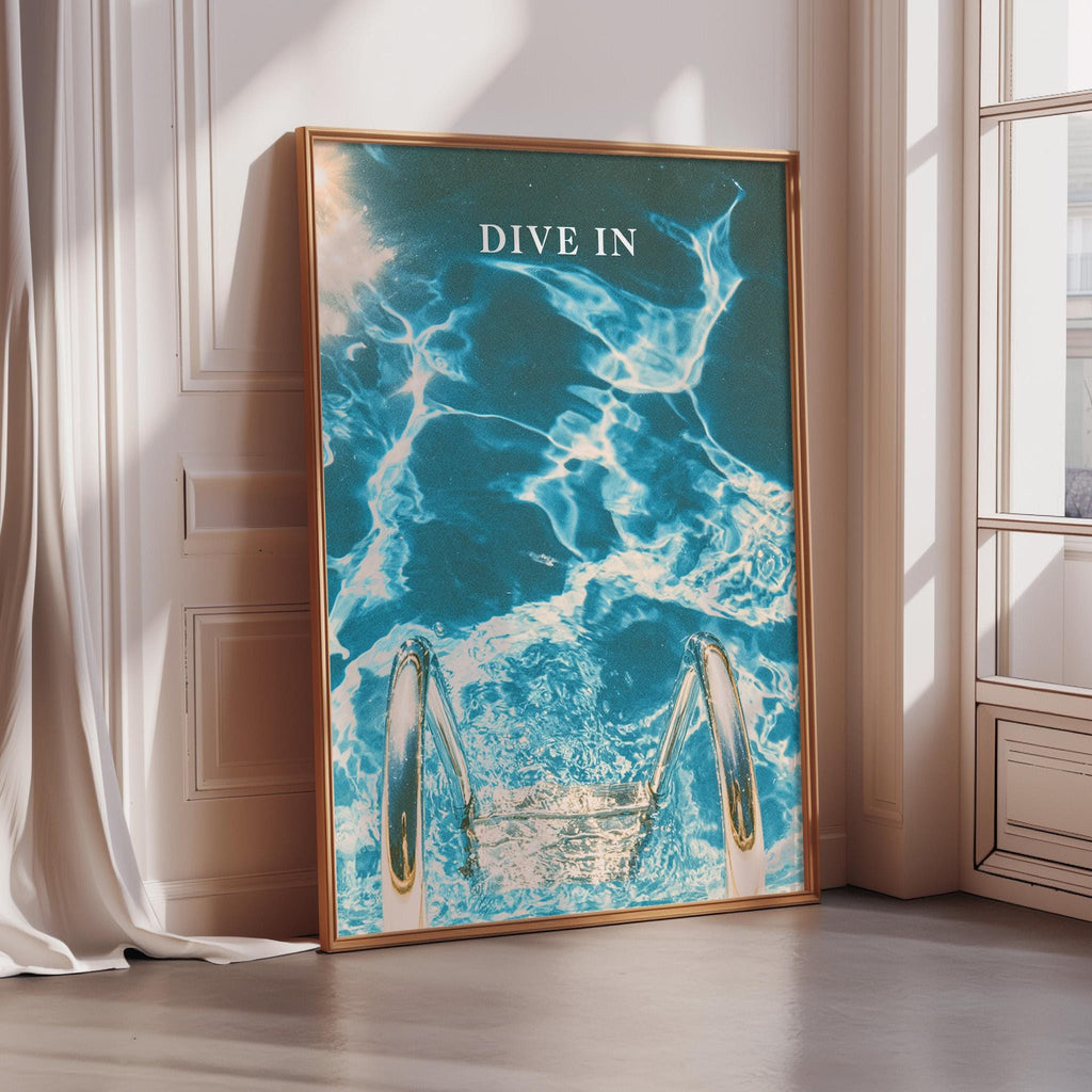 a framed poster with a blue and white ocean scene, featuring a pair of diving fins and the text "DIVE IN".