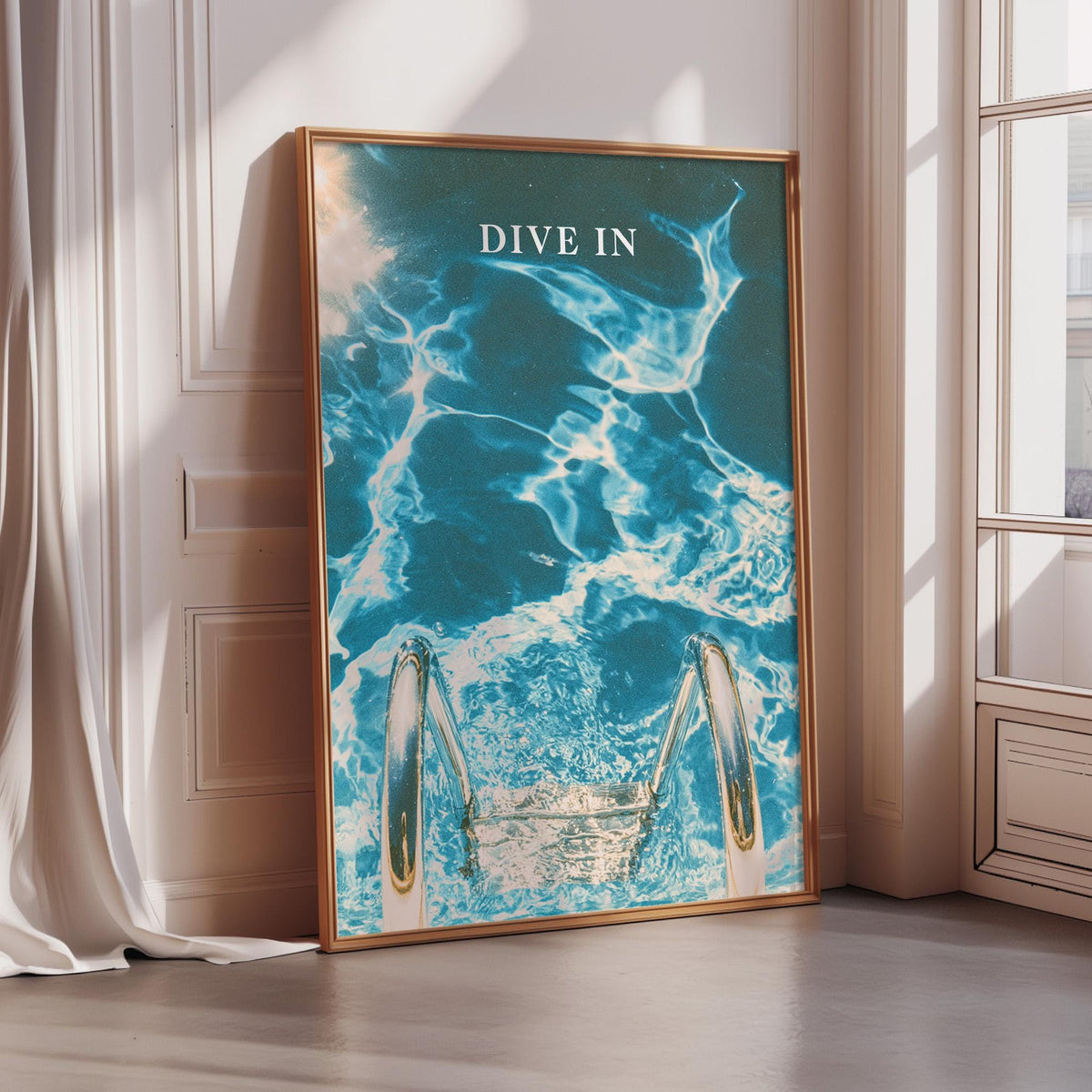 a framed poster with a blue and white ocean scene, featuring a pair of diving fins and the text "DIVE IN".