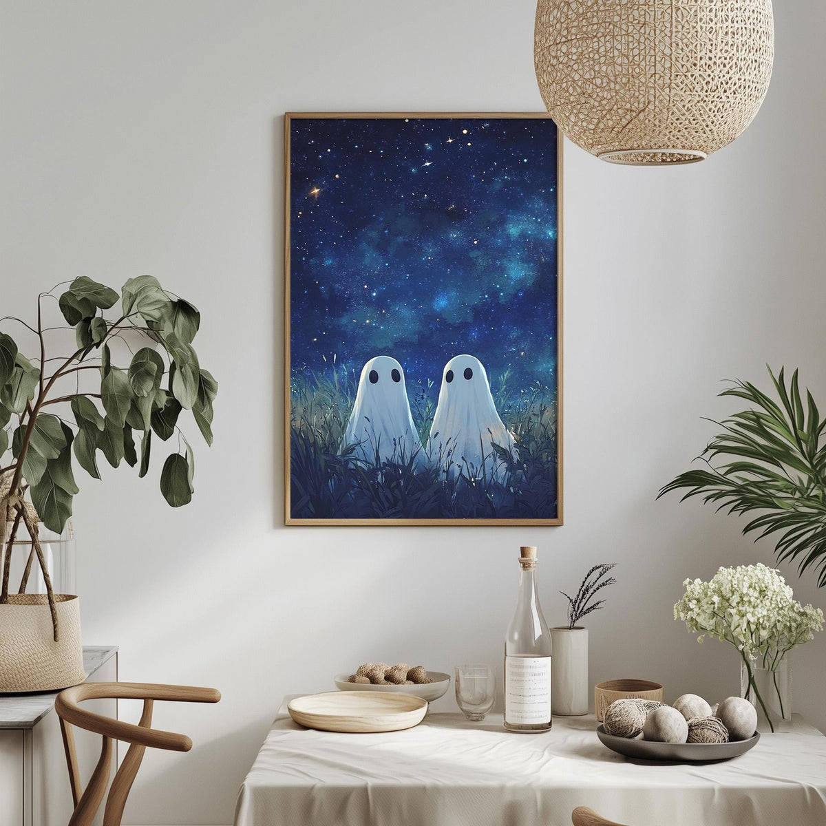 a cozy dining area with a table set for two, a potted plant, a hanging light fixture, and a framed artwork depicting two ghostly figures in a starry night scene.