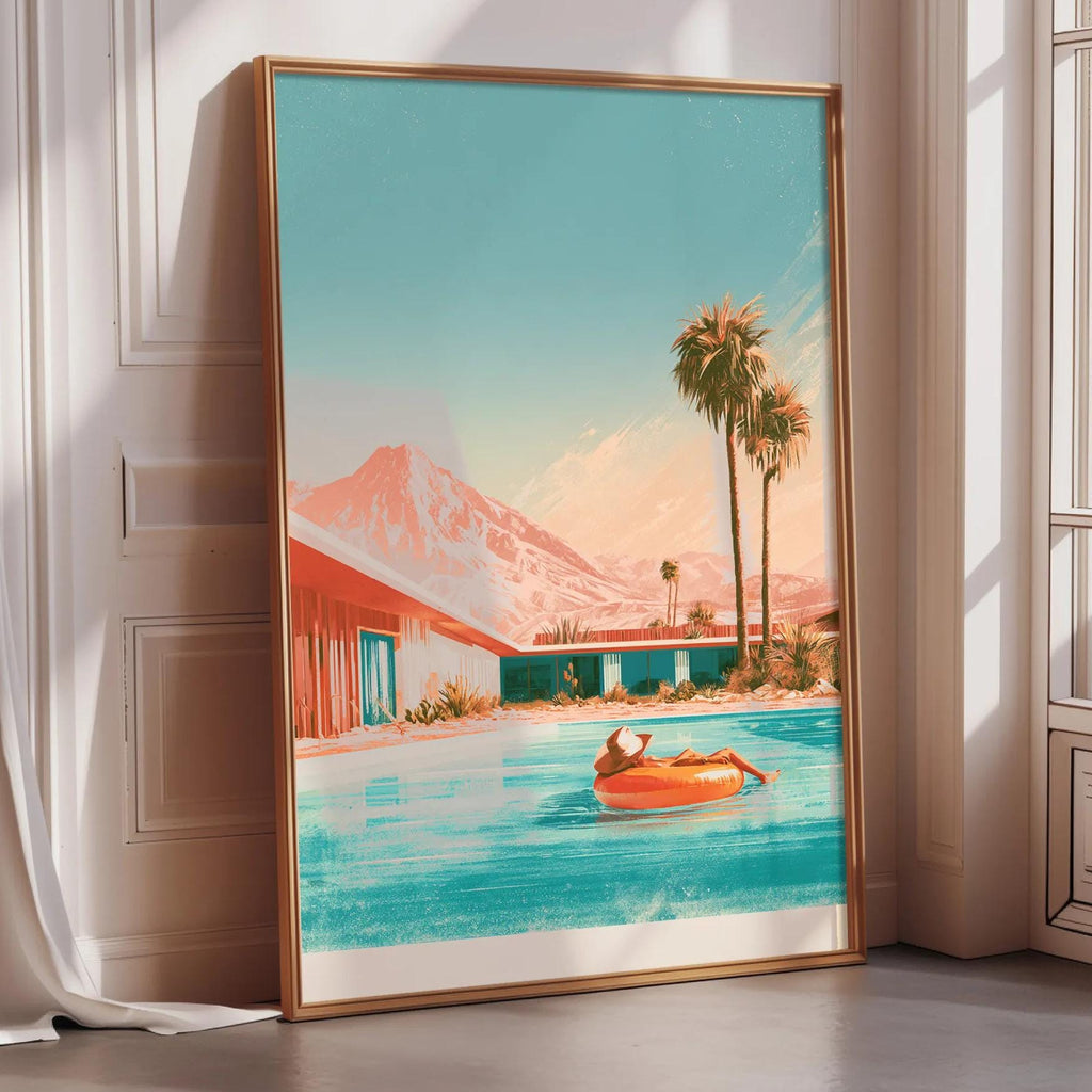 A framed painting depicting a person relaxing on a float in a pool, with palm trees and mountains in the background.