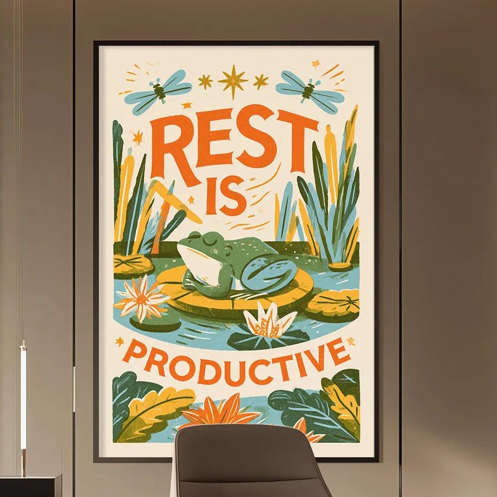 a modern office space with a large poster on the wall that says "REST IS PRODUCTIVE". The office has a wooden desk, a chair, and a bookshelf. The overall design has a minimalist and contemporary aesthetic.