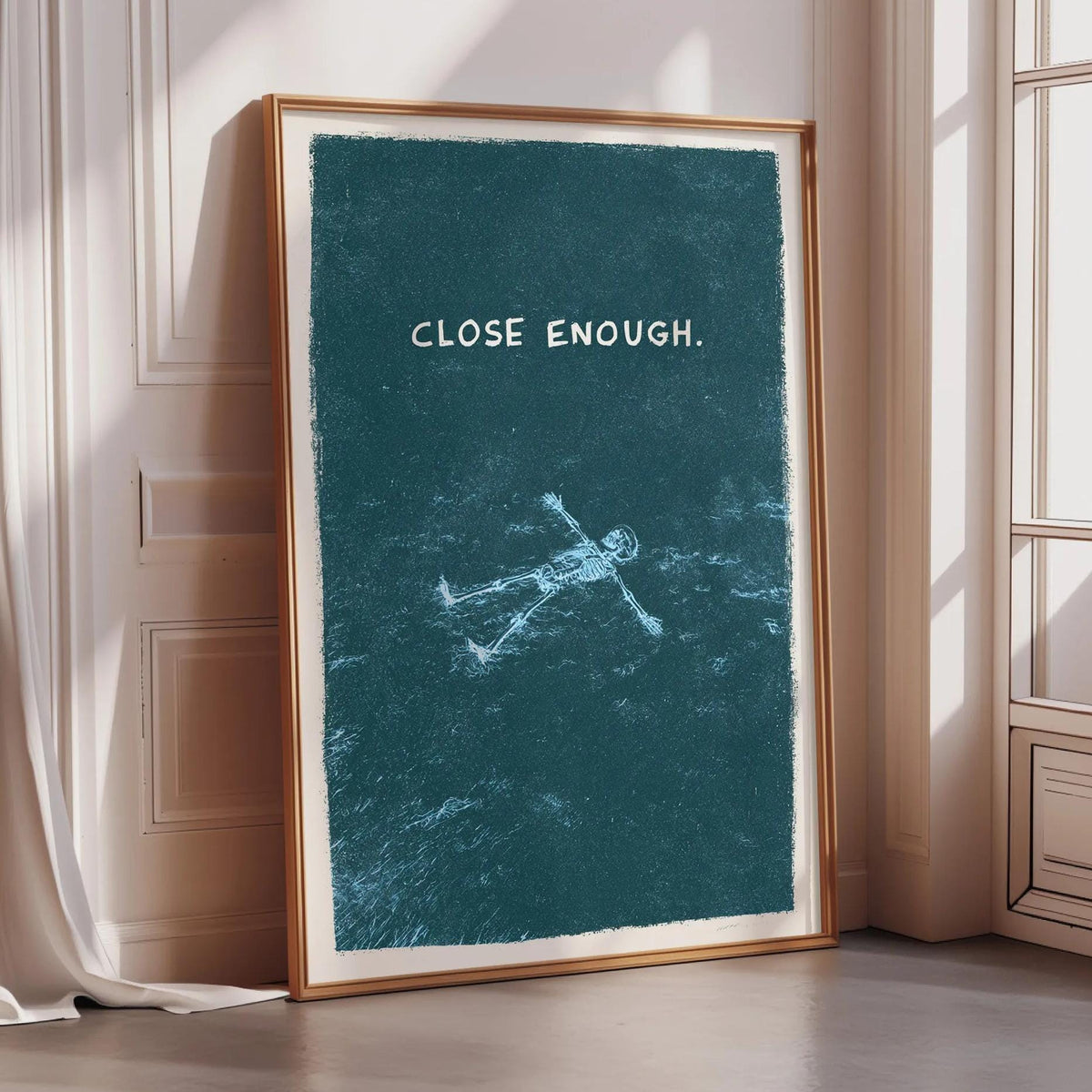 a framed poster with the text "CLOSE ENOUGH" and a drawing of a person floating in water.