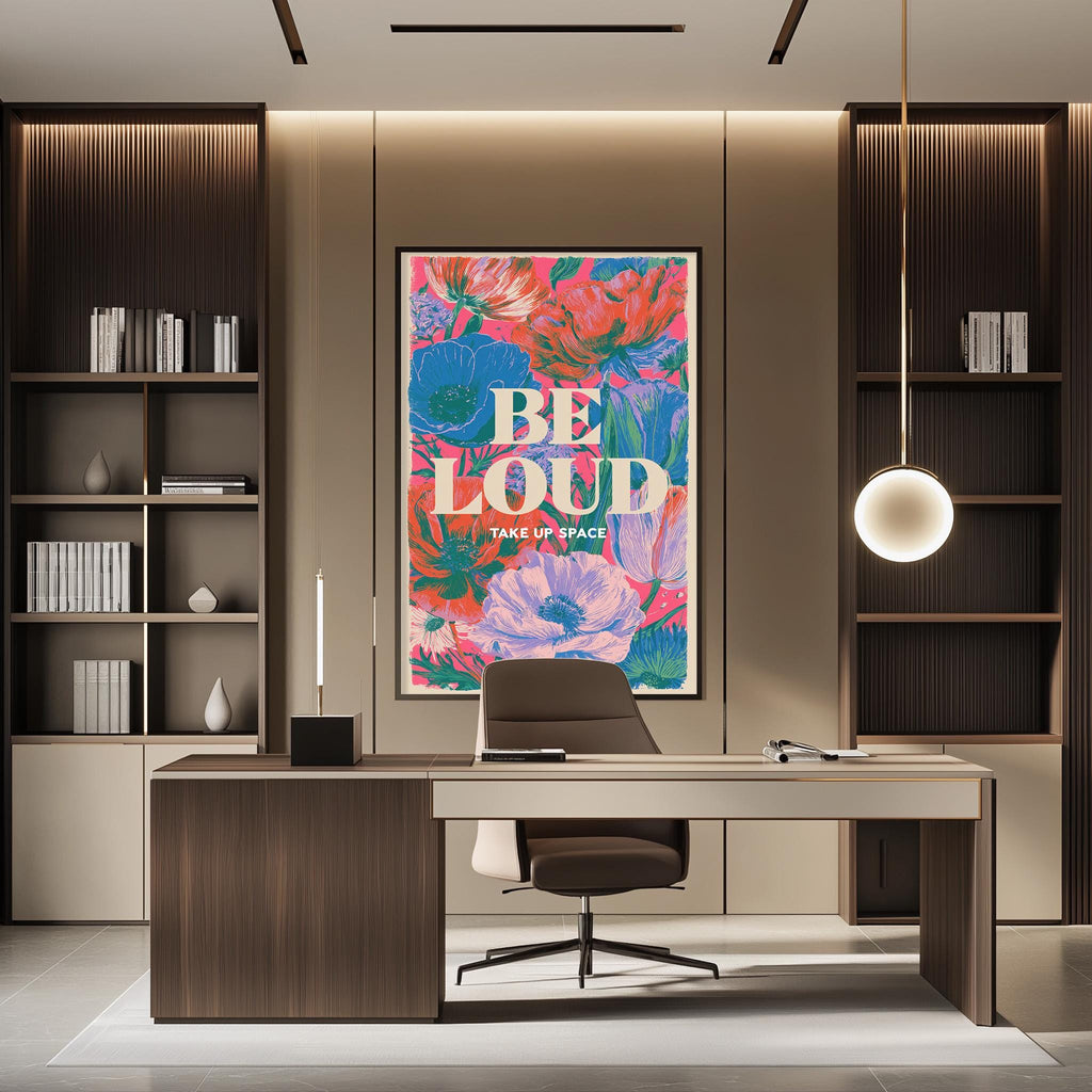 a modern office space with a large floral poster on the wall that says "BE LOUD TAKE UP SPACE". The office has a wooden desk, a chair, and a bookshelf filled with books. The overall design and decor create a professional and stylish atmosphere.