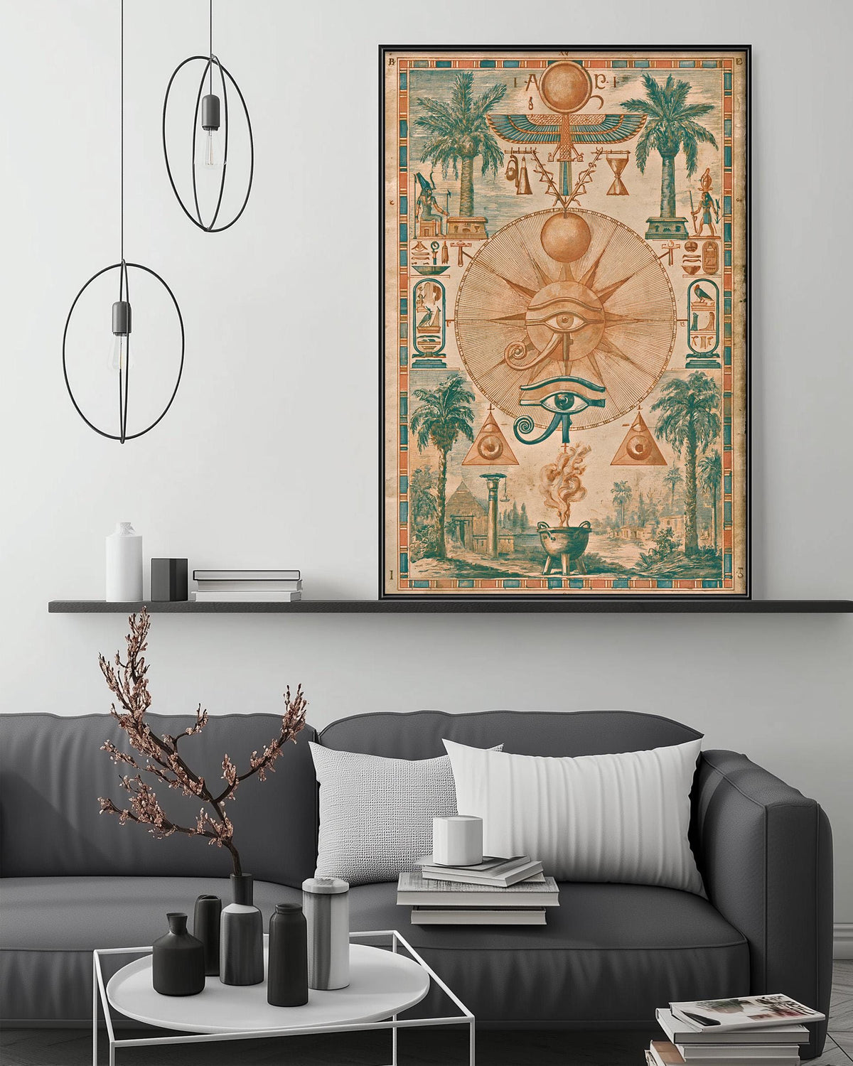 a large framed artwork depicting an ancient Egyptian scene with various symbols and imagery, including a prominent eye surrounded by palm trees and other Egyptian motifs. The artwork is displayed above a gray couch in a living room setting, with a coffee table and other decorative items visible below.