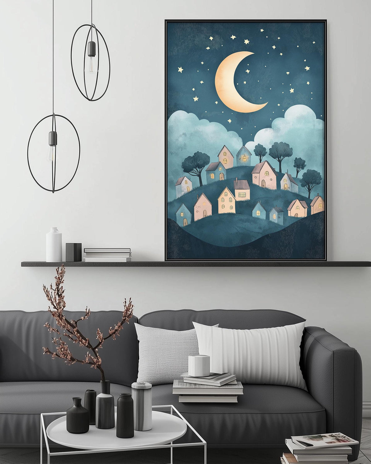 a cozy living room with a gray sofa, a coffee table, and a large framed illustration of a village under a night sky with a crescent moon and stars.