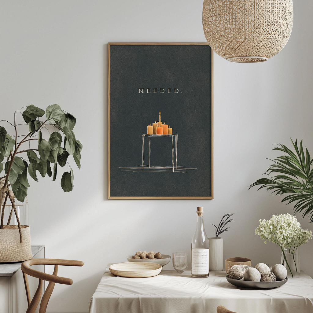 a dining table with a white tablecloth, a bowl of fruit, a bottle, and a vase with flowers. Above the table, there is a framed poster with a drawing of a cake and the word "NEEDED" written on it.
