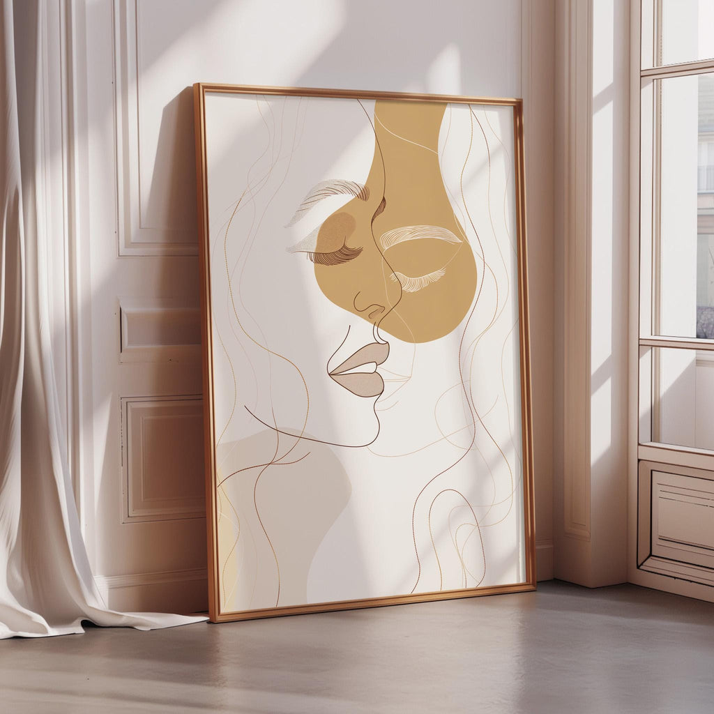 a large abstract portrait of a woman's face, with a gold frame, placed on a wooden floor in a room with a window.
