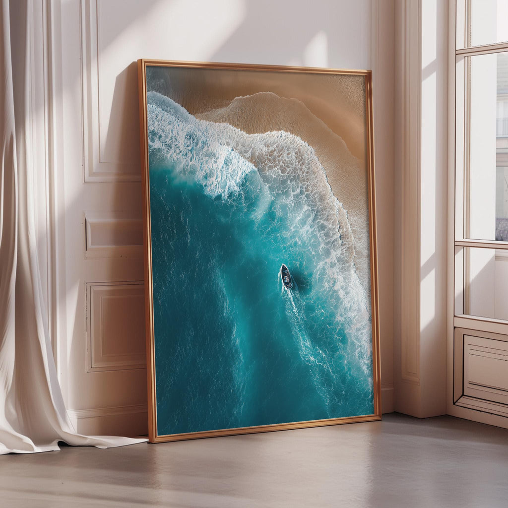 A large framed picture depicting a serene ocean scene with a small boat on the water, set against a backdrop of a sandy beach.