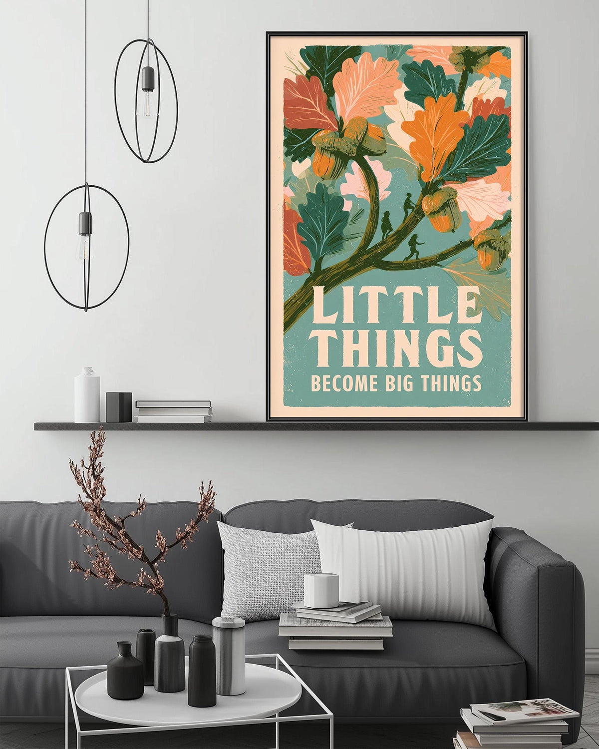 a framed poster with a vibrant illustration of leaves and acorns, accompanied by the text "LITTLE THINGS BECOME BIG THINGS" displayed on a wall above a gray couch.
