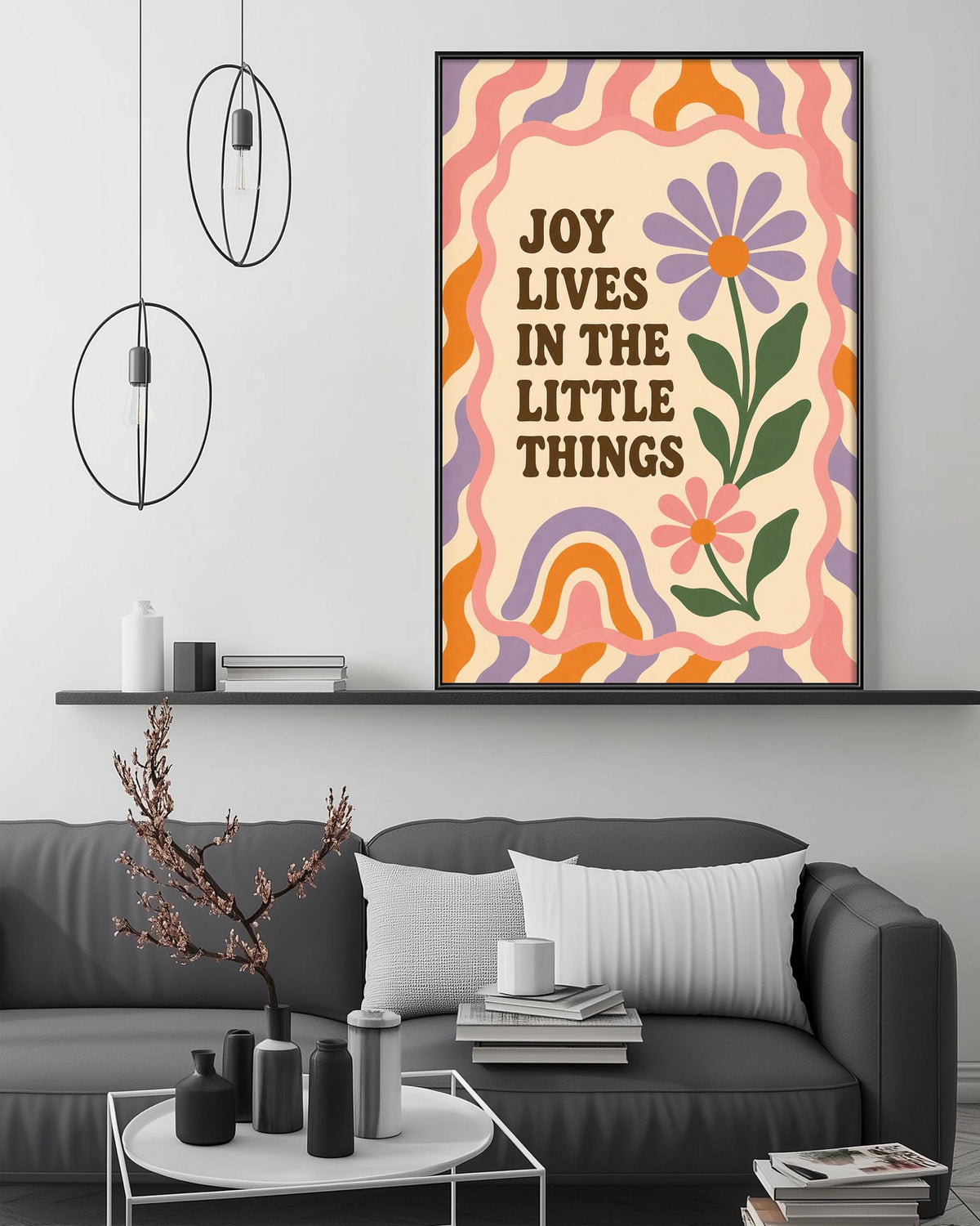 a living room with a gray couch, a coffee table, and a framed poster with a flower design and text on the wall.