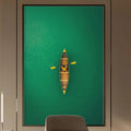 a modern office space with a large green wall art piece featuring a boat on the water. The office has a wooden desk, a comfortable-looking chair, and a bookshelf filled with books. The overall design and decor create a calm and professional atmosphere.