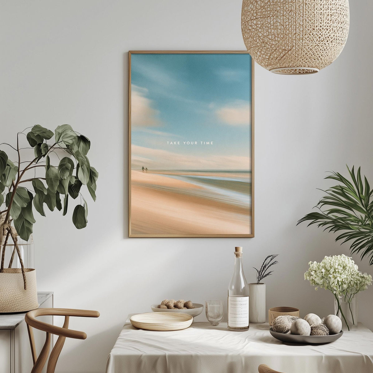a serene beach scene with a framed picture hanging on the wall, surrounded by various decorative elements such as potted plants, a table set with plates and a bottle, and a hanging light fixture.