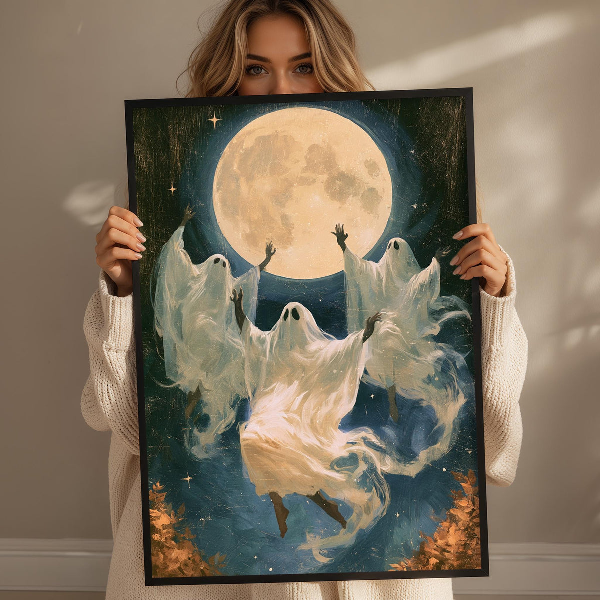 A woman holds up a framed painting depicting a group of ghostly figures floating in the night sky, with a large full moon in the background.