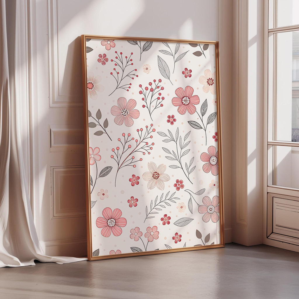 A framed poster with a floral pattern of pink flowers and leaves is displayed on a wall in a room with a window.