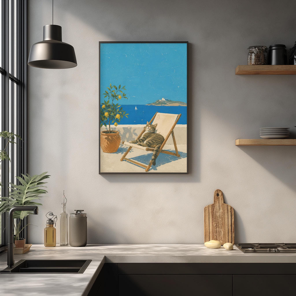 a kitchen counter with various items on it, including a potted plant, a vase, a soap dish, and a cutting board. Above the counter, there is a framed painting depicting a cat sitting in a chair on a balcony overlooking the ocean.