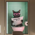 a modern office space with a large framed poster of a cat sitting in a pink toilet, reading a newspaper. The poster is mounted on the wall above a desk with a chair.