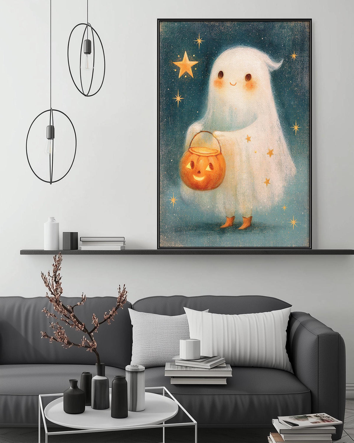 a cozy living room with a gray couch, a coffee table, and a large framed illustration of a ghost holding a pumpkin and a star above it.