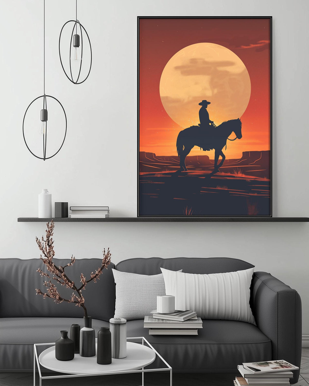 a large framed picture of a cowboy riding a horse against a backdrop of a sunset. The cowboy is silhouetted against the vibrant orange and yellow sky, creating a striking visual contrast. The cowboy is positioned on the right side of the frame, while the horse is on the left. The cowboy is holding a lasso, suggesting he may be preparing to throw it. The cowboy is standing on a dirt road, which adds to the overall rustic and western theme of the scene.