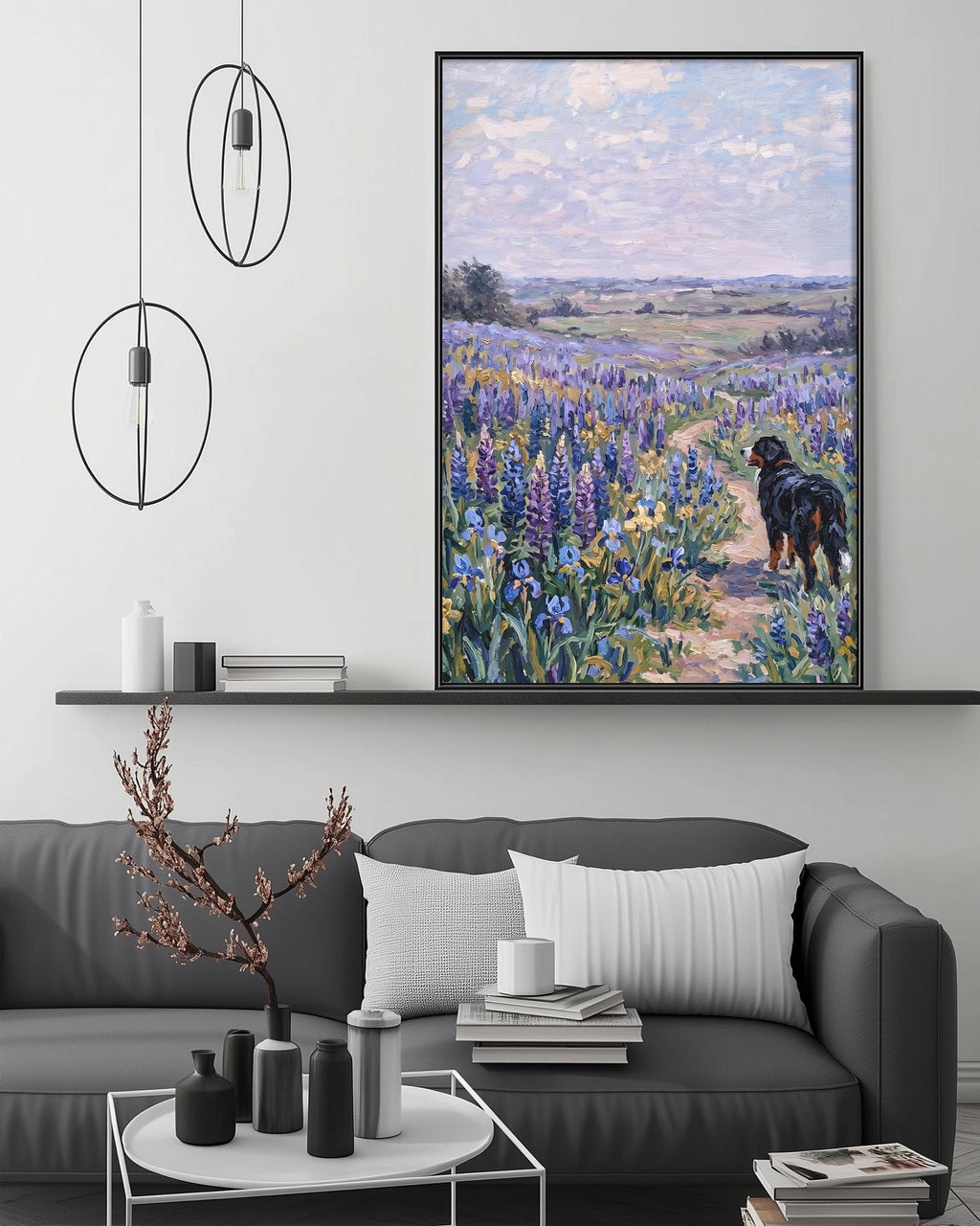 a large painting of a dog walking through a field of flowers, hanging on a wall above a gray couch with a coffee table in front of it.