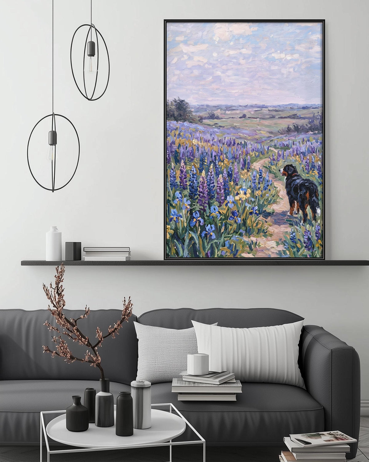 a large painting of a dog walking through a field of flowers, hanging on a wall above a gray couch with a coffee table in front of it.