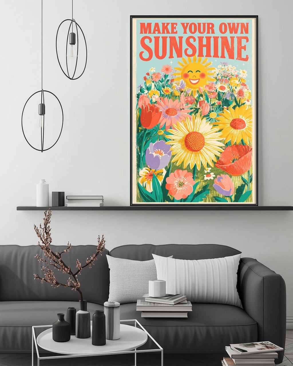a large framed poster with a vibrant illustration of flowers and a sun, hanging on a wall above a gray couch in a living room setting.