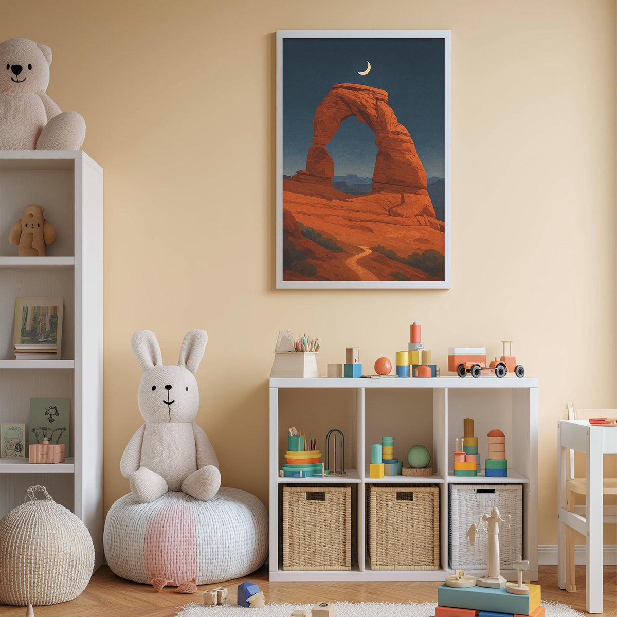A cozy children's room with a large white stuffed rabbit sitting on a bean bag chair, surrounded by shelves filled with toys and books. A framed picture of a desert landscape with a crescent moon hangs on the wall, and a toy train set is visible on a shelf below the picture.