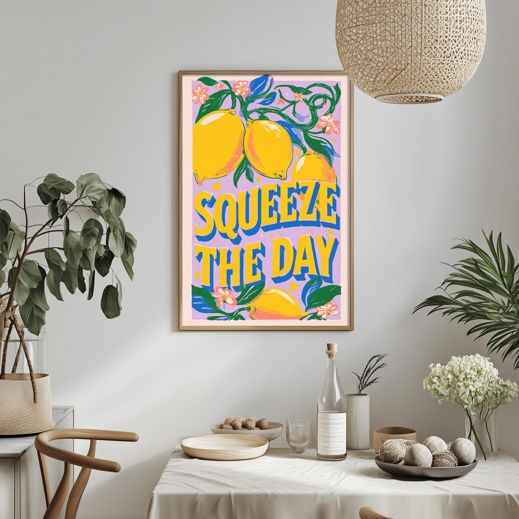 a framed poster with the text "SQUEEZE THE DAY" hanging on a wall above a dining table with various items on it.