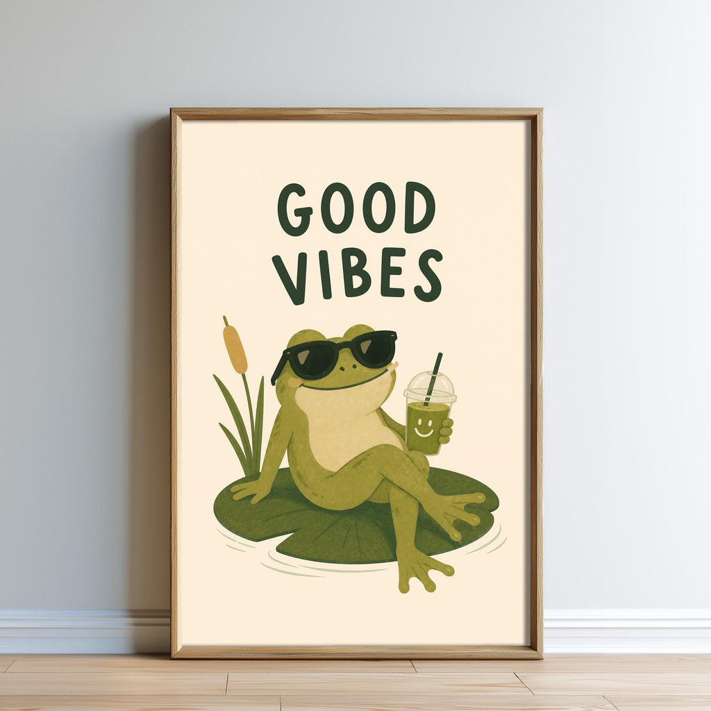 A framed poster featuring a cartoon frog sitting on a lily pad, wearing sunglasses and holding a drink, with the text "GOOD VIBES" above the image.
