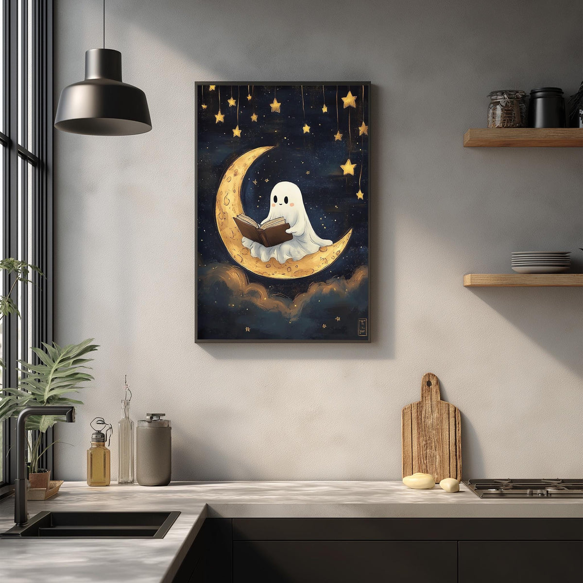 a framed artwork depicting a ghost reading a book on a crescent moon, surrounded by stars, in a kitchen setting with a wooden cutting board and other kitchen items.