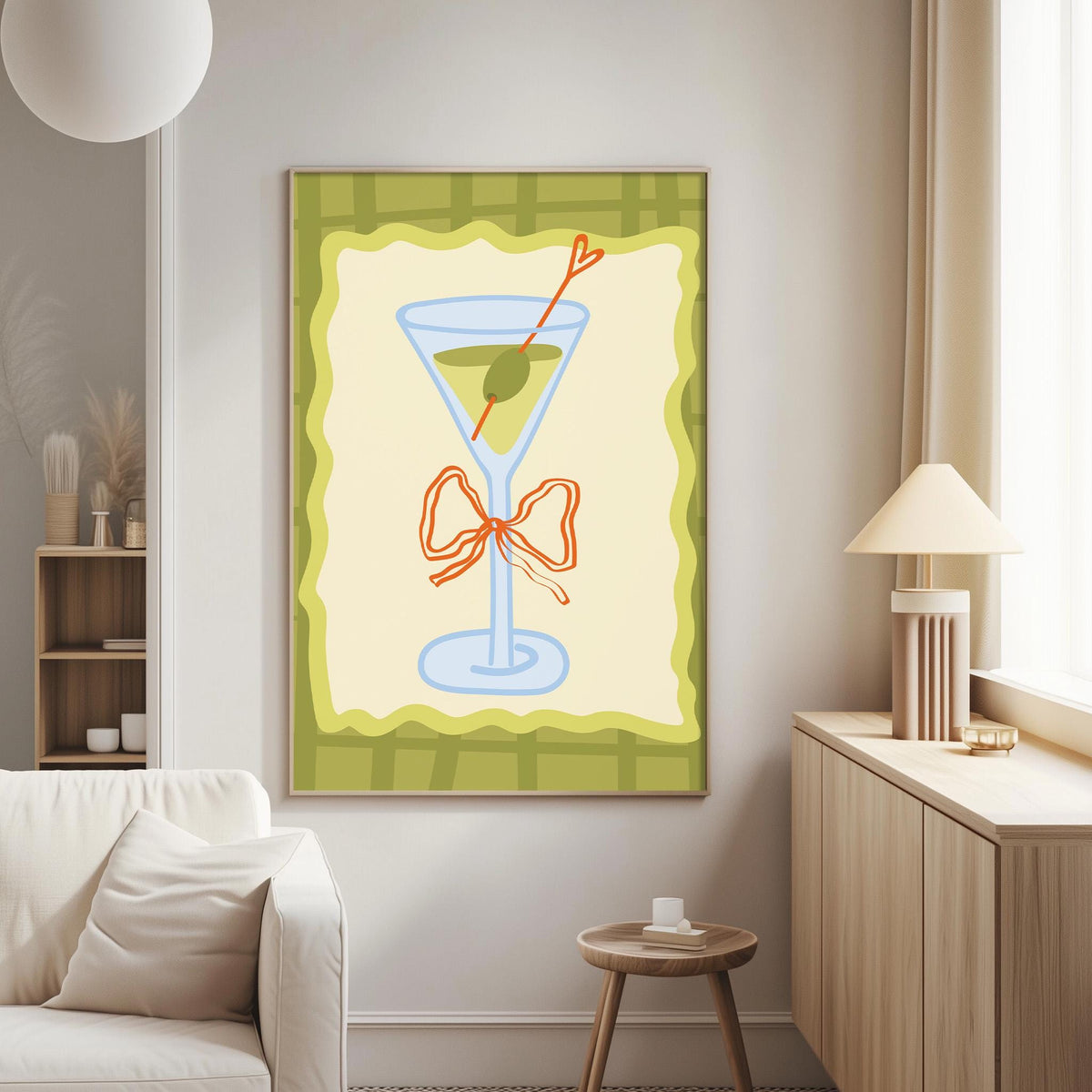a living room with a white couch, a wooden side table, and a framed artwork depicting a martini glass with a bow on it.