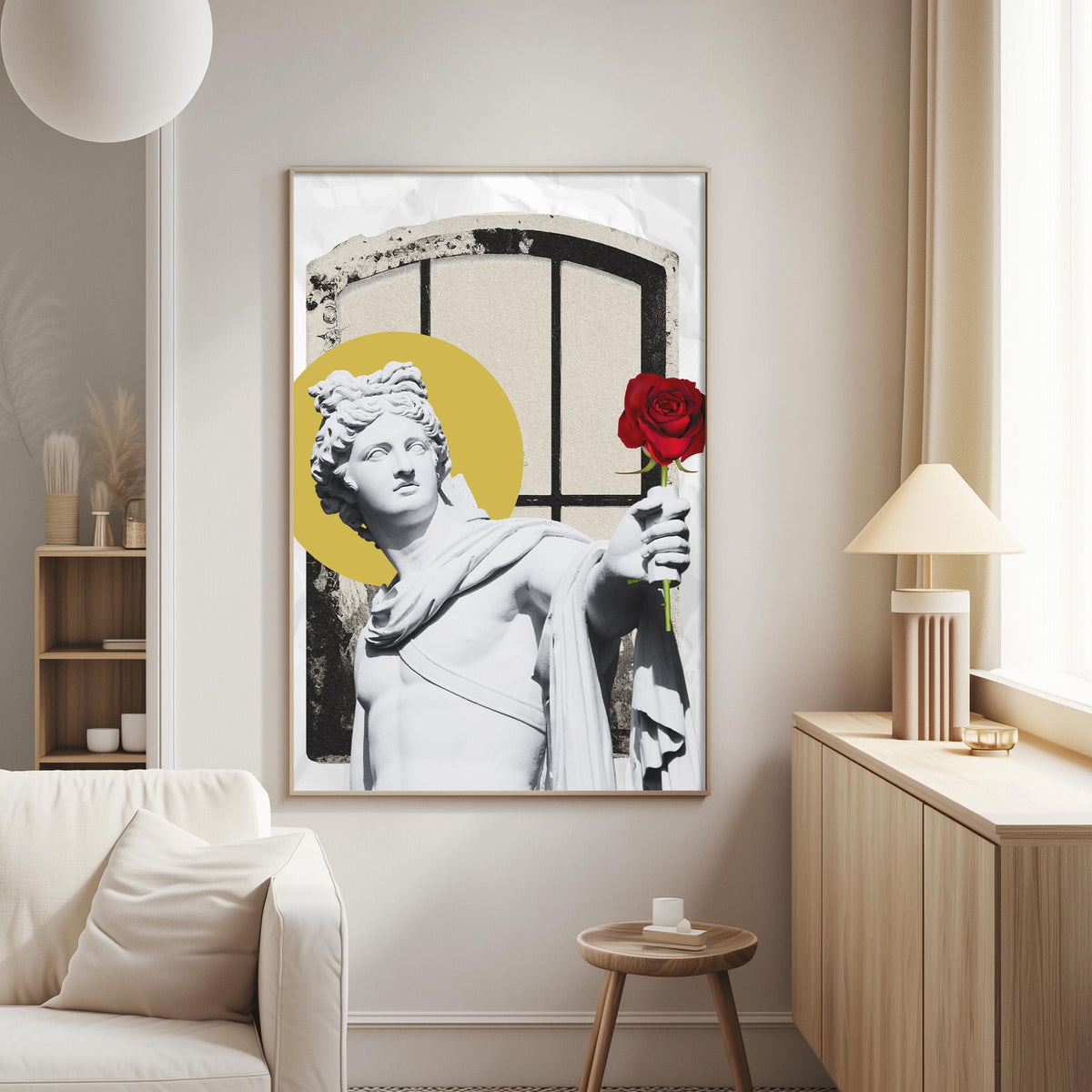 a large framed artwork depicting a white statue of a man holding a red rose, with a yellow circle in the background. The artwork is displayed on a wall in a living room setting, with a white couch and a wooden side table visible in the background.