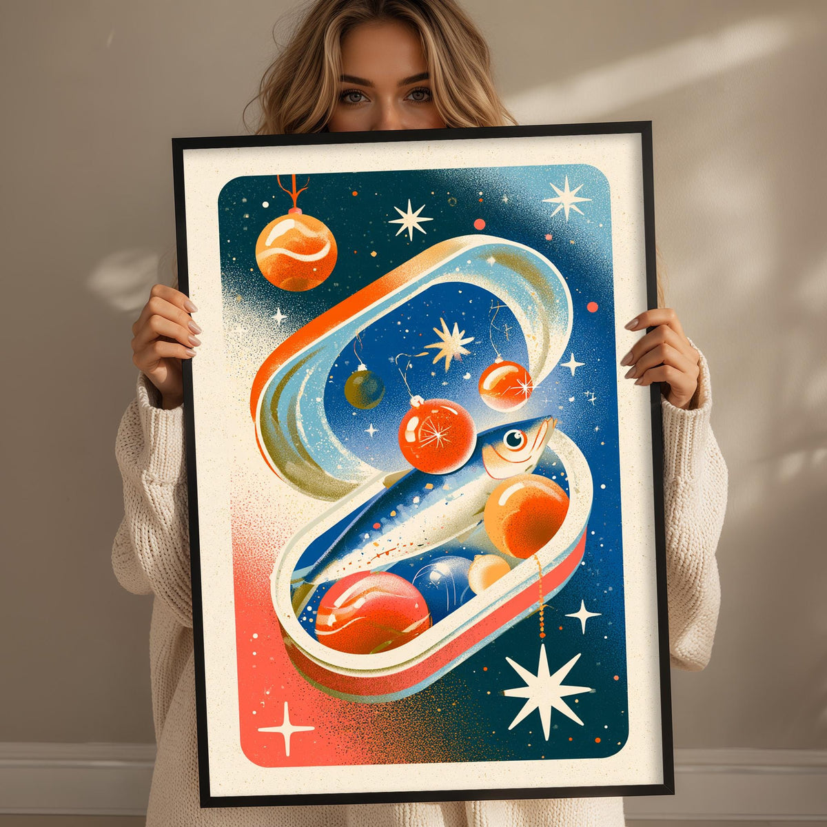 A woman is holding up a framed artwork depicting a whimsical, space-themed scene with various celestial objects and a fish-like creature.