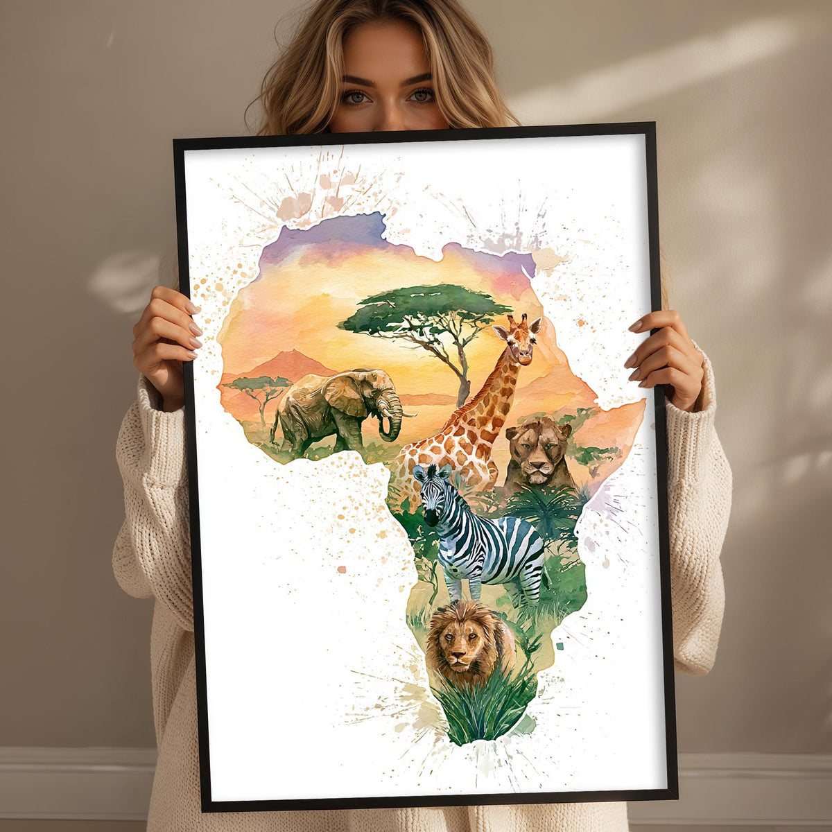 A woman holds up a framed print depicting a vibrant illustration of African wildlife, including elephants, giraffes, zebras, and lions, set against a colorful, watercolor-style background.