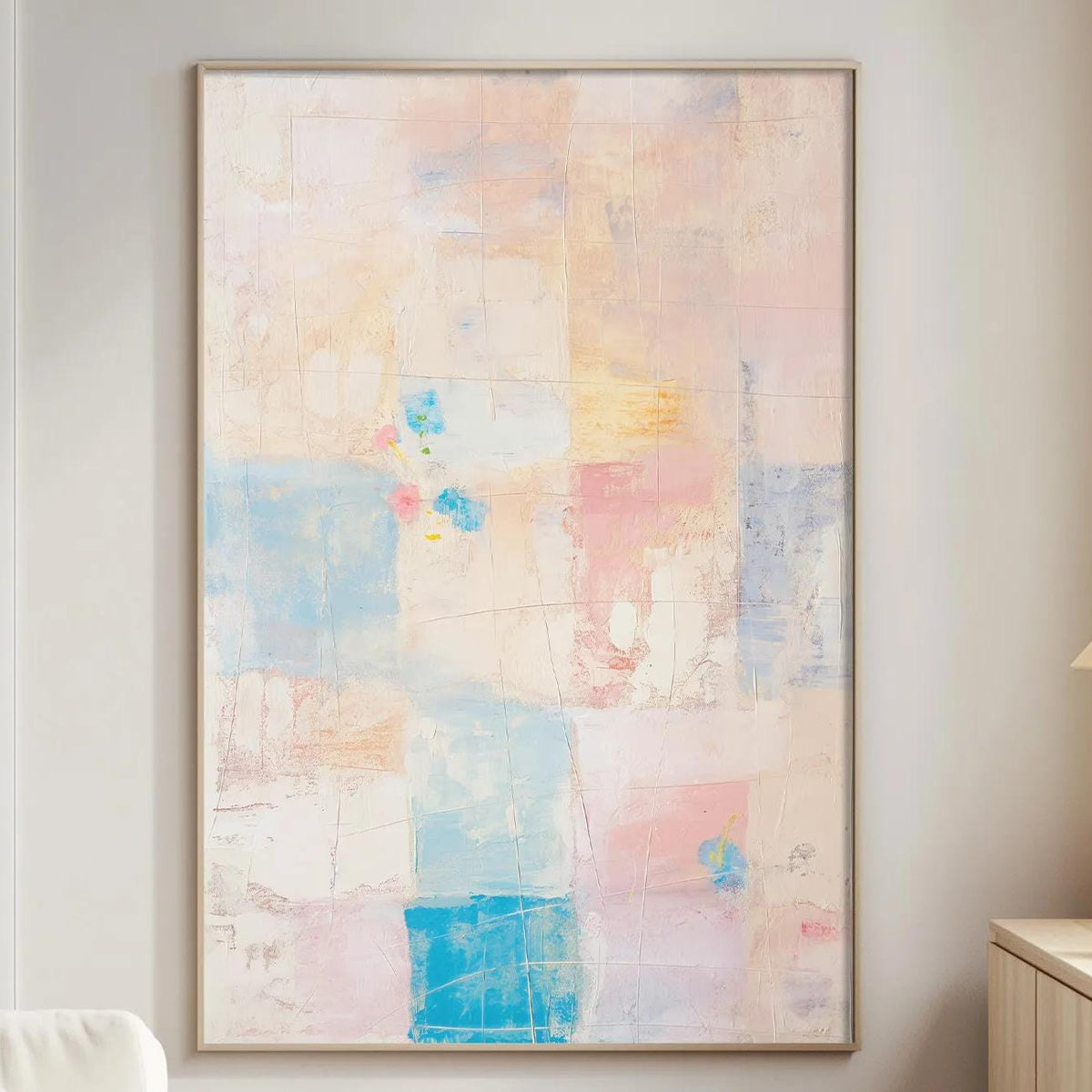 a living room with a large abstract painting hanging on the wall, a white sofa, a wooden side table, and a lamp on a wooden cabinet.