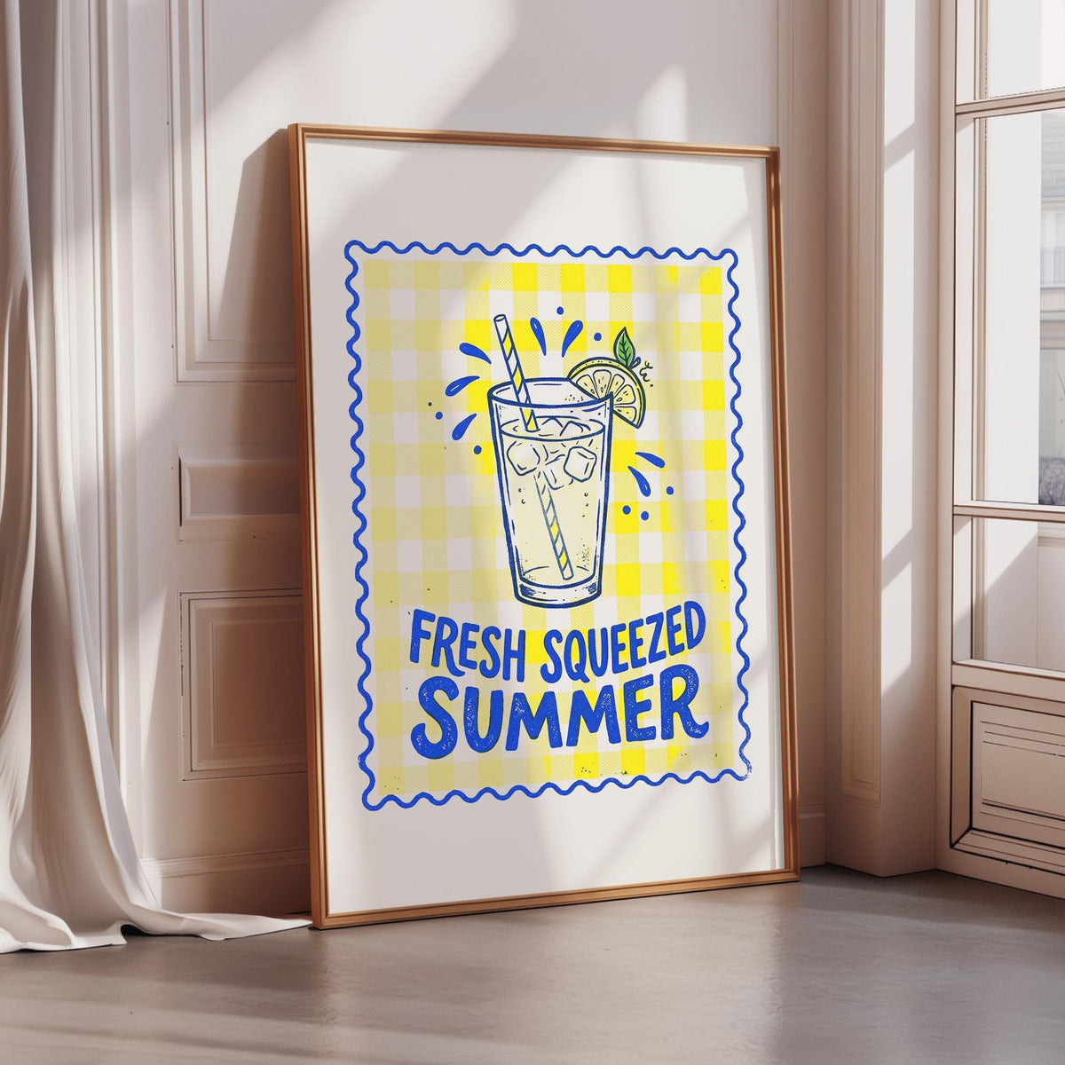 A framed poster with a yellow and blue checkered background, depicting a glass of lemonade with a lemon slice and straw. The text on the poster reads "FRESH SQUEEZED SUMMER".